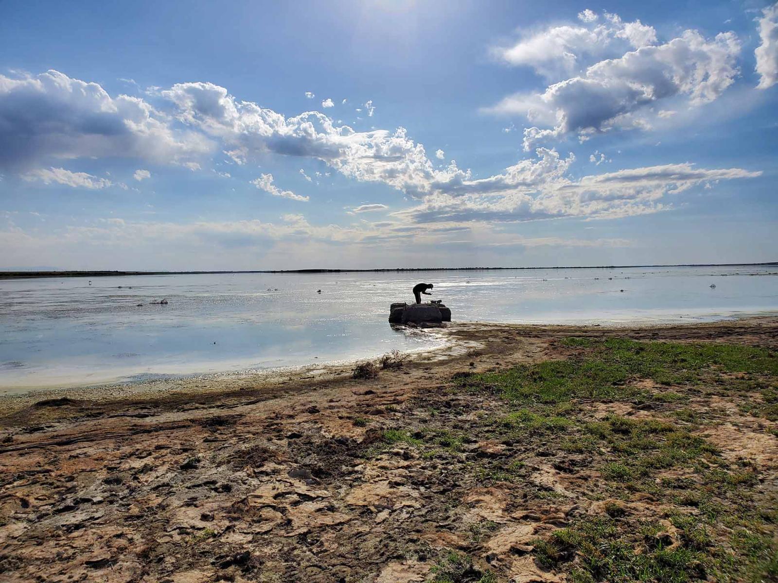 Person working on edge of lake